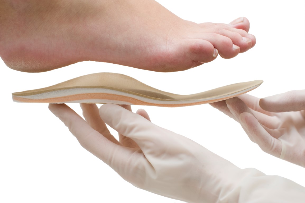 Custom orthotic insole being fitted beneath a foot